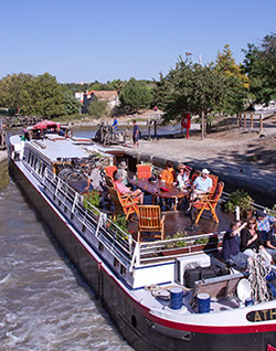 People enjoying the sun deck on the canal